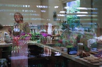 a woman standing in front of a mirror in a kitchen