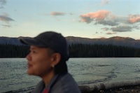 a woman wearing a hat looking out over a body of water