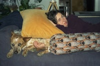 a woman laying on a couch with a dog